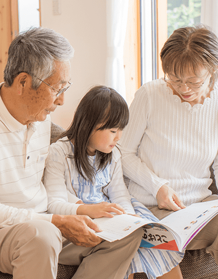 絵本を読む祖父母と孫